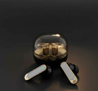 BGT Gold earbuds out of transparent case on dark background - gold and black finish