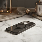 iPhone 15 Pro Max black magnetic case lying flat on marble surface - lifestyle shot