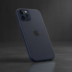 iPhone 15 navy blue silicone case on phone angled on dark reflective surface - dramatic lighting